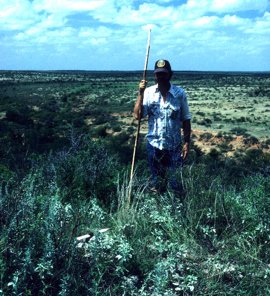 photo of Wayne Chesser marking the location of a possible cairn on bluff edge at 41CC237