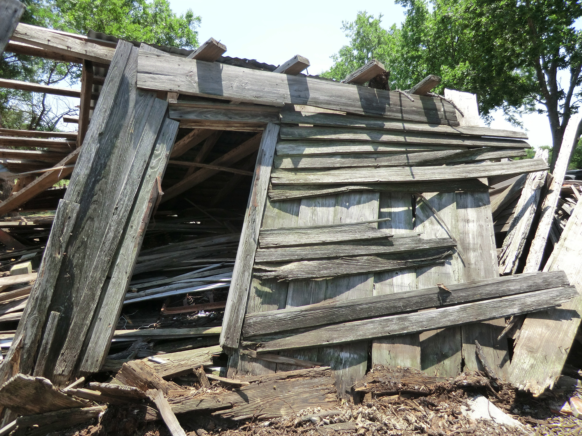 color photo of collapsed wooden house entrance before excavation