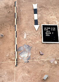 Pottery-making tools on the floor of Room 7, including a pottery jar rim template, a polishing pebble, and large sherd dish or palette.