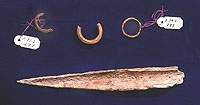 Bone awl and burned bone rings found in an irregular trash-filled pit between rooms 13 and 17.