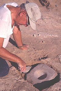 Hal Siros uncovers a finely shaped mortar and pestle set cached in pit of Room 15, one of the pithouses found beneath the pueblo.