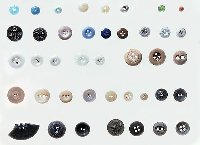 Beads and buttons, both fancy and plain, provide a glimpse of how rural folk dressed near the turn of the century. The two black glass buttons on second row at left have ornate molded designs and may have come from Victorian period mourning style dresses of the late 1800s. At the far right of the same row are transfer-printed ceramic buttons with black and green calico designs; these were made from the 1840s to about 1900. Other buttons range from a tiny mother-of-pearl button used for infant's clothing to metal buttons from men's overalls.