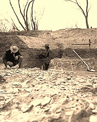 An archeologist examines a feature on the southwest edge of the "Great Midden."