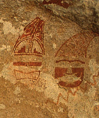 photo of paired red masks, each with conical caps