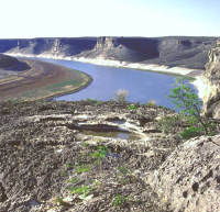 View of the lower Devils River valley now partially filled by Amistad Reservoir. In prehistoric times, the wider terraces along this stretch of the river were shaded by massive oak trees and a favored camping spot. Photo by Steve Black.