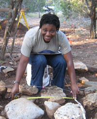 photo of Nedra Lee taking a measurement of a portion of the foundation footing in the cabin area. 
