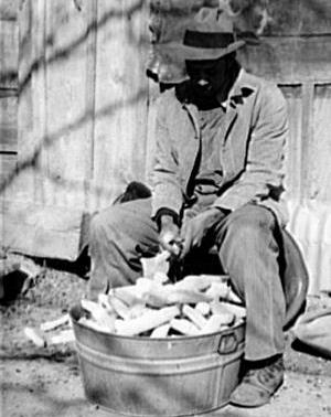 1940s photo of a man shelling corn