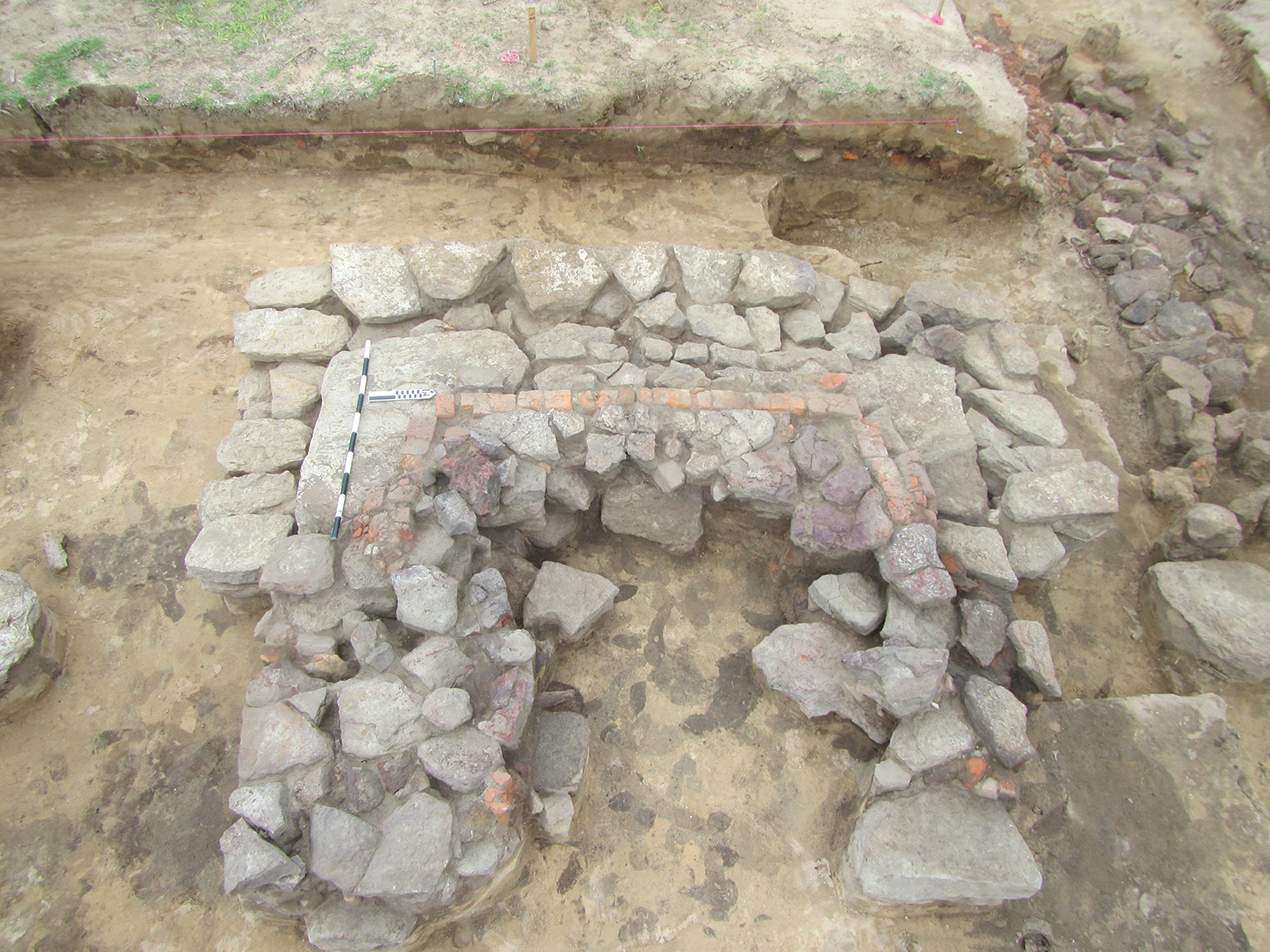 Photo of excavation exposure of U-shaped arrangement of bricks