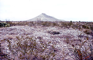 Photo of one of the site's burned rock middens with Squawteat Peak looming in distance