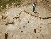 photo of Jack Hughes standing hear an excavated house